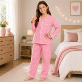 Young girl in pink pajamas standing in a bedroom