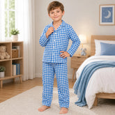 Child wearing blue checkered pajamas in a bedroom setting