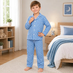 Child wearing blue checkered pajamas in a bedroom setting