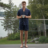 Man standing on a rooftop with urban buildings and greenery in the background