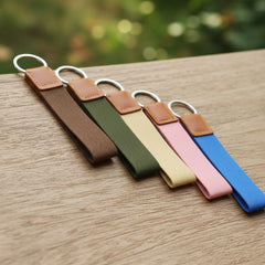 Set of colorful keychains with leather ends on a wooden surface