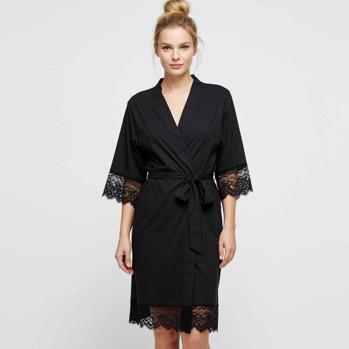 Woman wearing a black robe with lace details on a white background