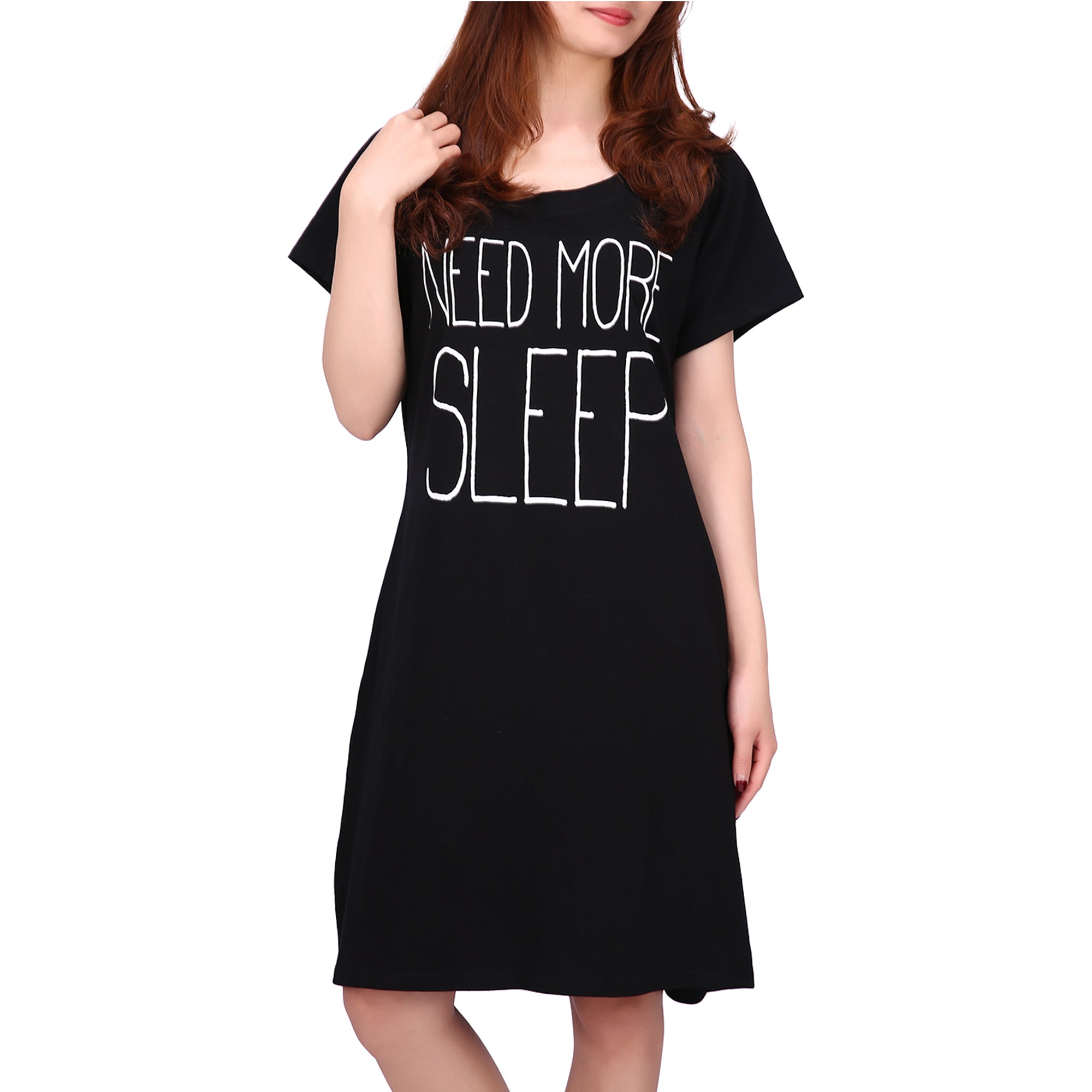 wearing a black nightdress featuring the printed text ‘Need More Sleep’ on the front.