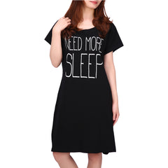 wearing a black nightdress featuring the printed text ‘Need More Sleep’ on the front.