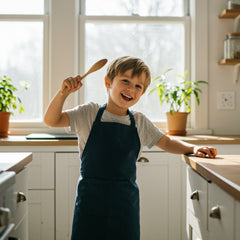 smiling child wearing kids cooking apron in bright kitchen