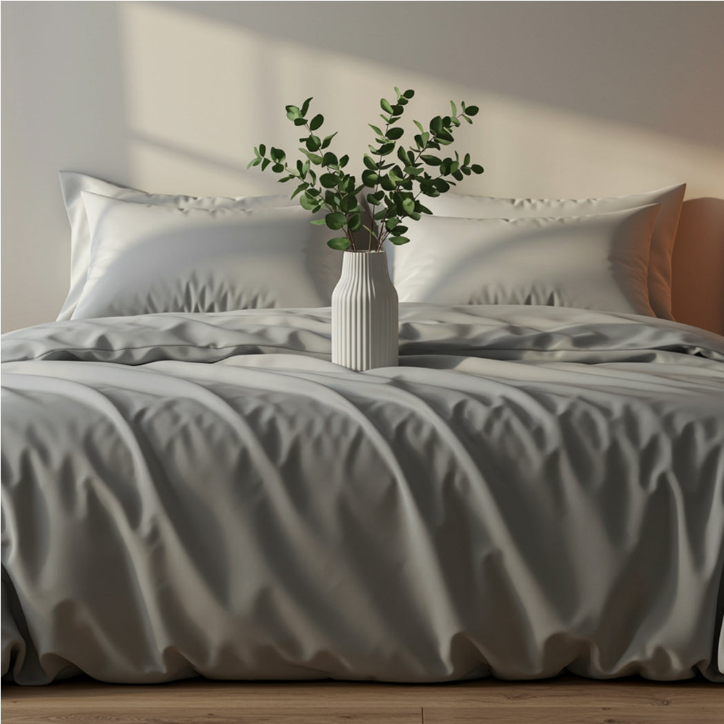 Rich ocean blue satin bed sheets draped elegantly with a white breakfast tray and blue flowers