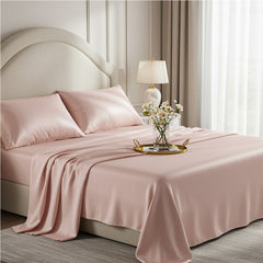 Blush rose pink silky satin bedsheet set with matching pillowcases on a modern cream bed
